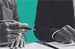 [ai] Two hands, one holding a pen and the other positioned over a document, with a turquoise background. The image captures a professional setting, possibly related to a meeting or signing of a agreement.